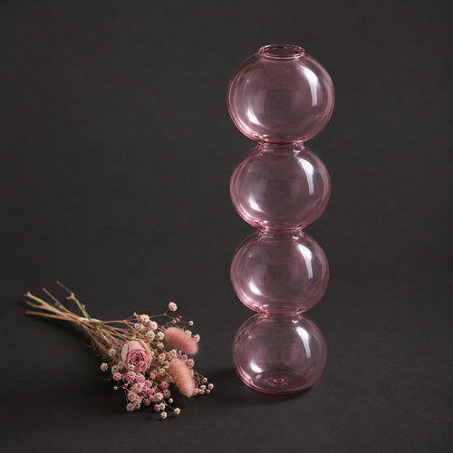 Jarrón Atelier de vidrio soplado rosa translúcido con forma de esferas apiladas, junto a un ramo de flores secas, fondo oscuro, edición limitada Neiro Objects